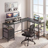 L-shaped black desk with power outlet, monitor stands, and open shelves for efficient workspace organization.