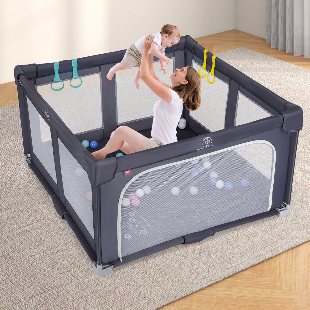 Large dark grey baby playpen with a child and parent, featuring pull-up rings and colorful ocean balls for play.