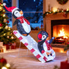 3D lighted Christmas decoration featuring two penguins on a slide, adorned with red hats and scarves, ideal for festive.