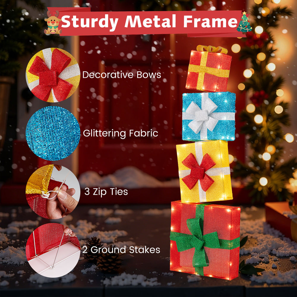 Stacked lighted gift boxes with decorative bows, glittering fabric, and a sturdy metal frame for festive outdoor.