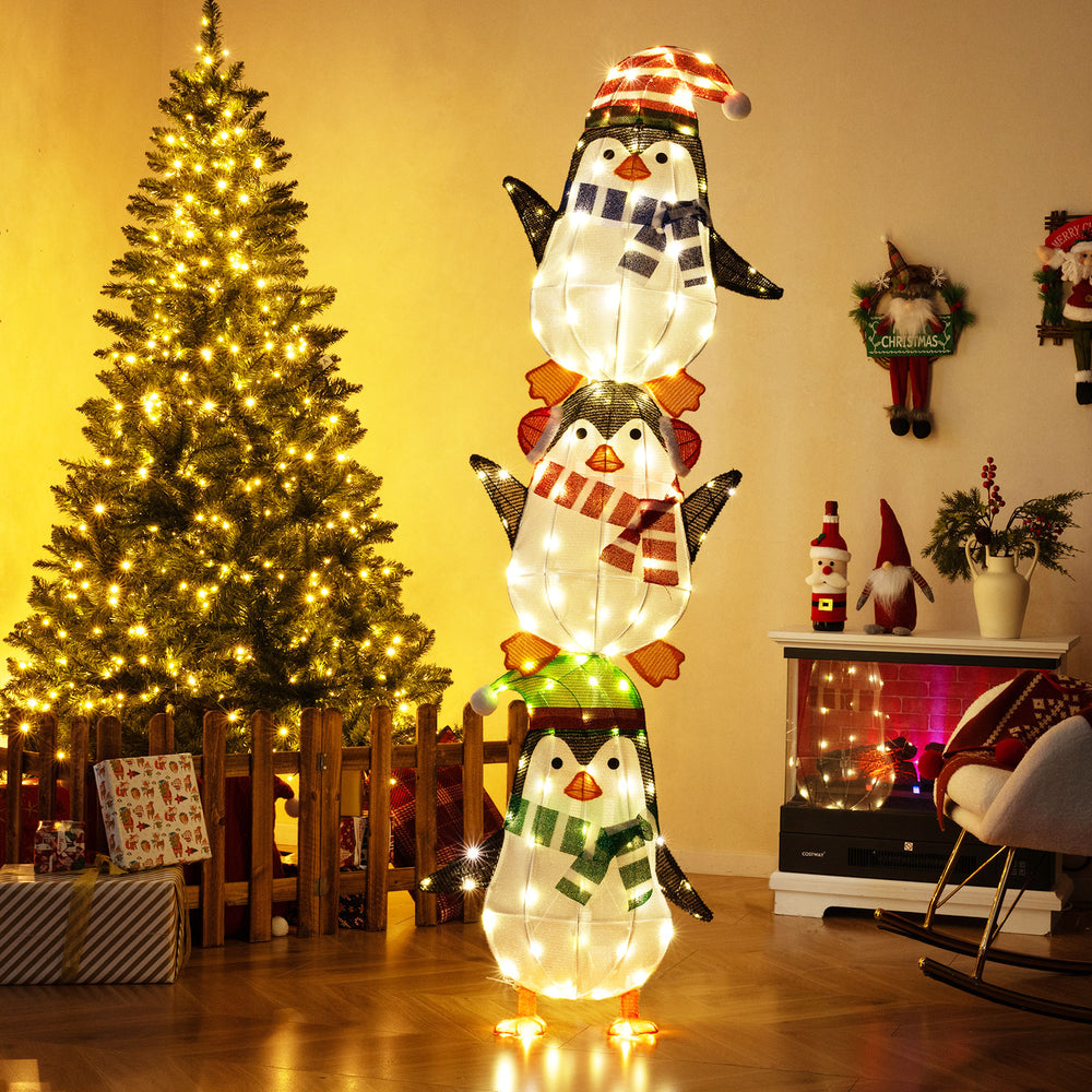Stacked lighted penguins decoration with warm white lights, festive hats, perfect for Christmas lawn or living room.