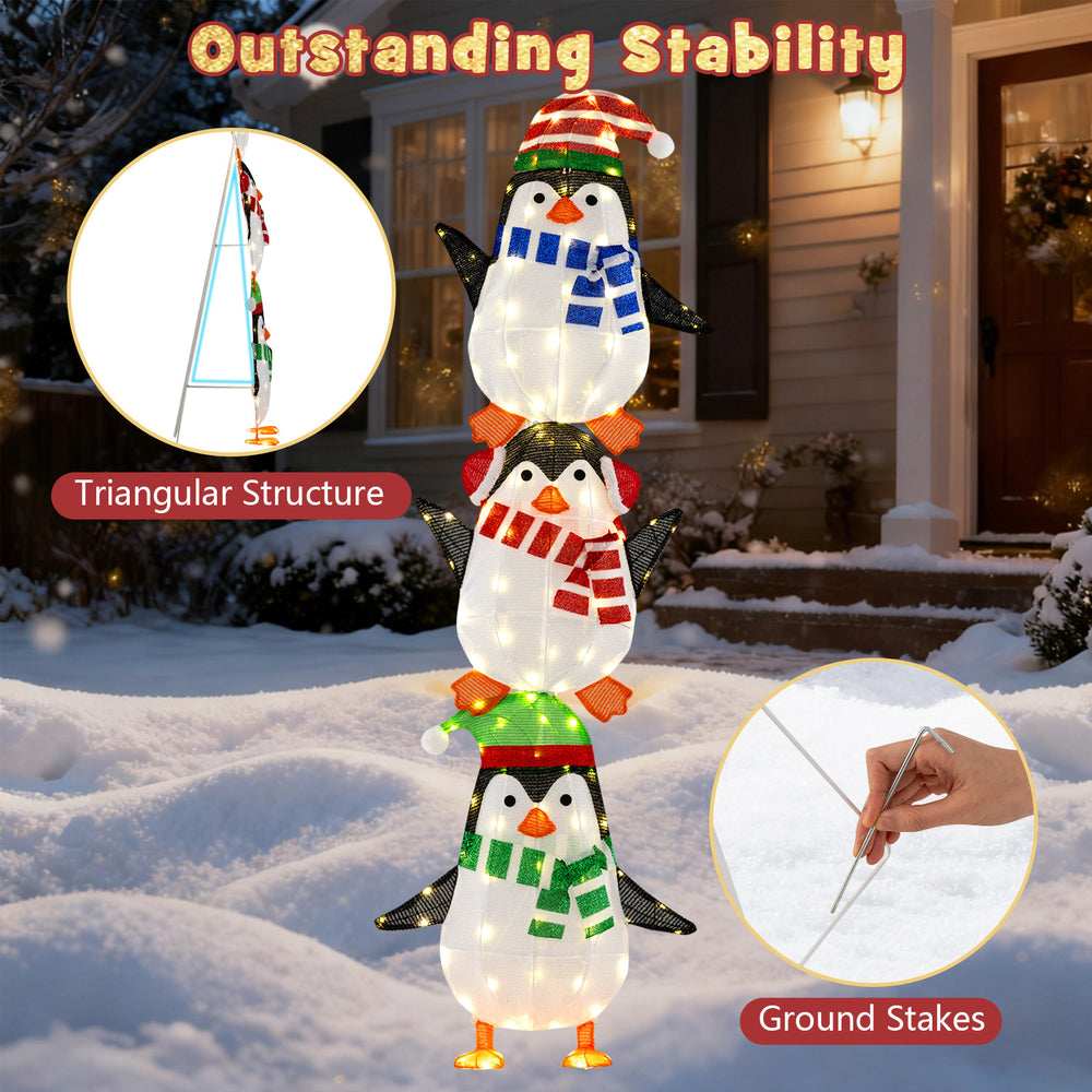 Close-up of lighted penguin decoration with warm white lights, showcasing colorful hats and stable triangular structure.