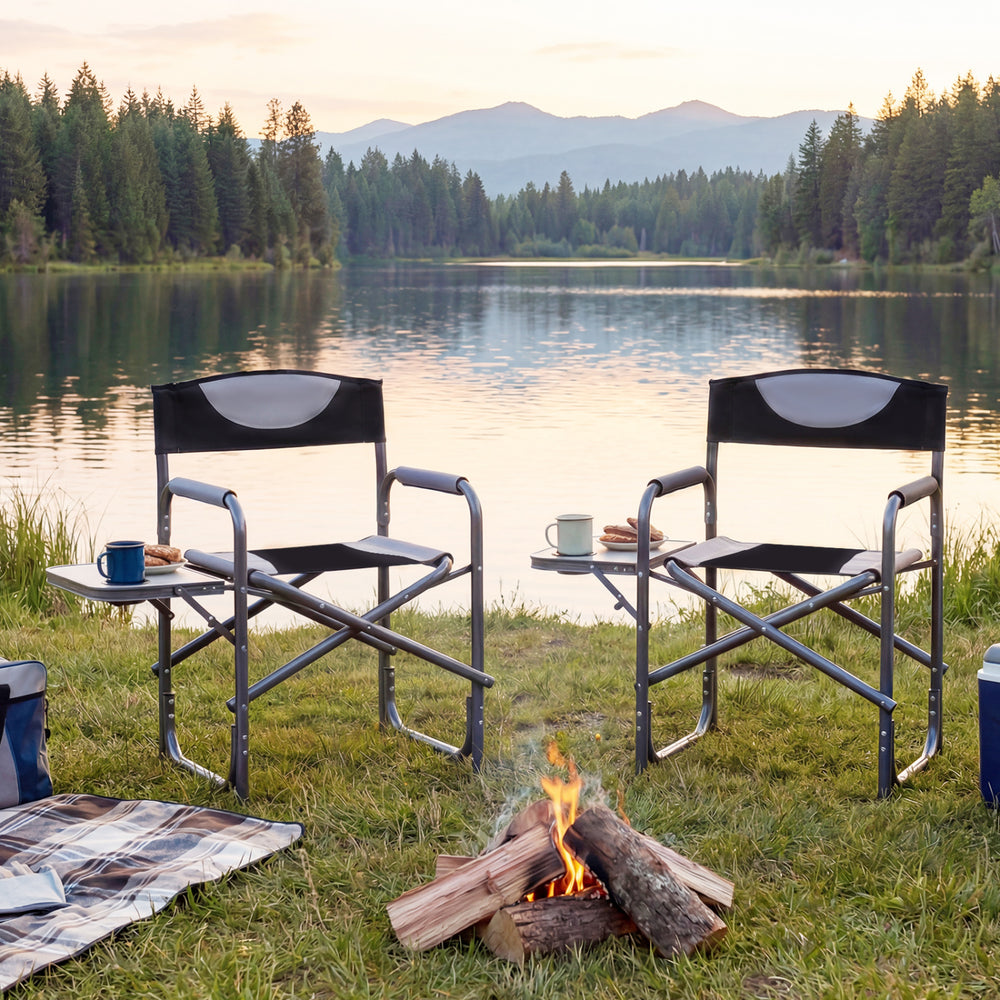 Lightweight folding camping chairs with side tables by a lake, featuring black 600D Oxford fabric and sturdy metal.