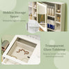 Makeup dressing table with a transparent glass tabletop and hidden storage behind a lighted mirror for organized beauty.