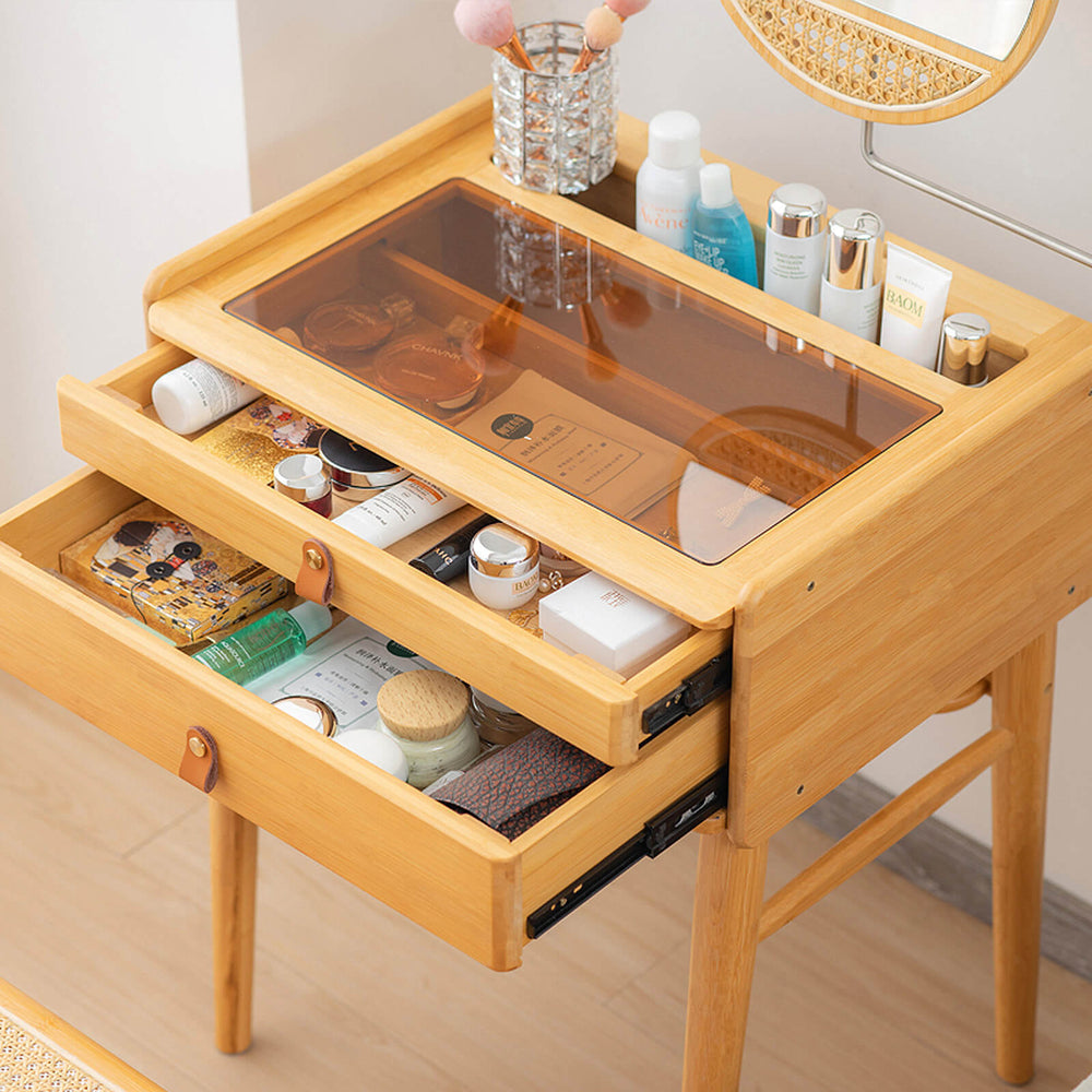 Bamboo makeup vanity table with two drawers, tempered glass top, and rotating mirror for organized cosmetics storage.