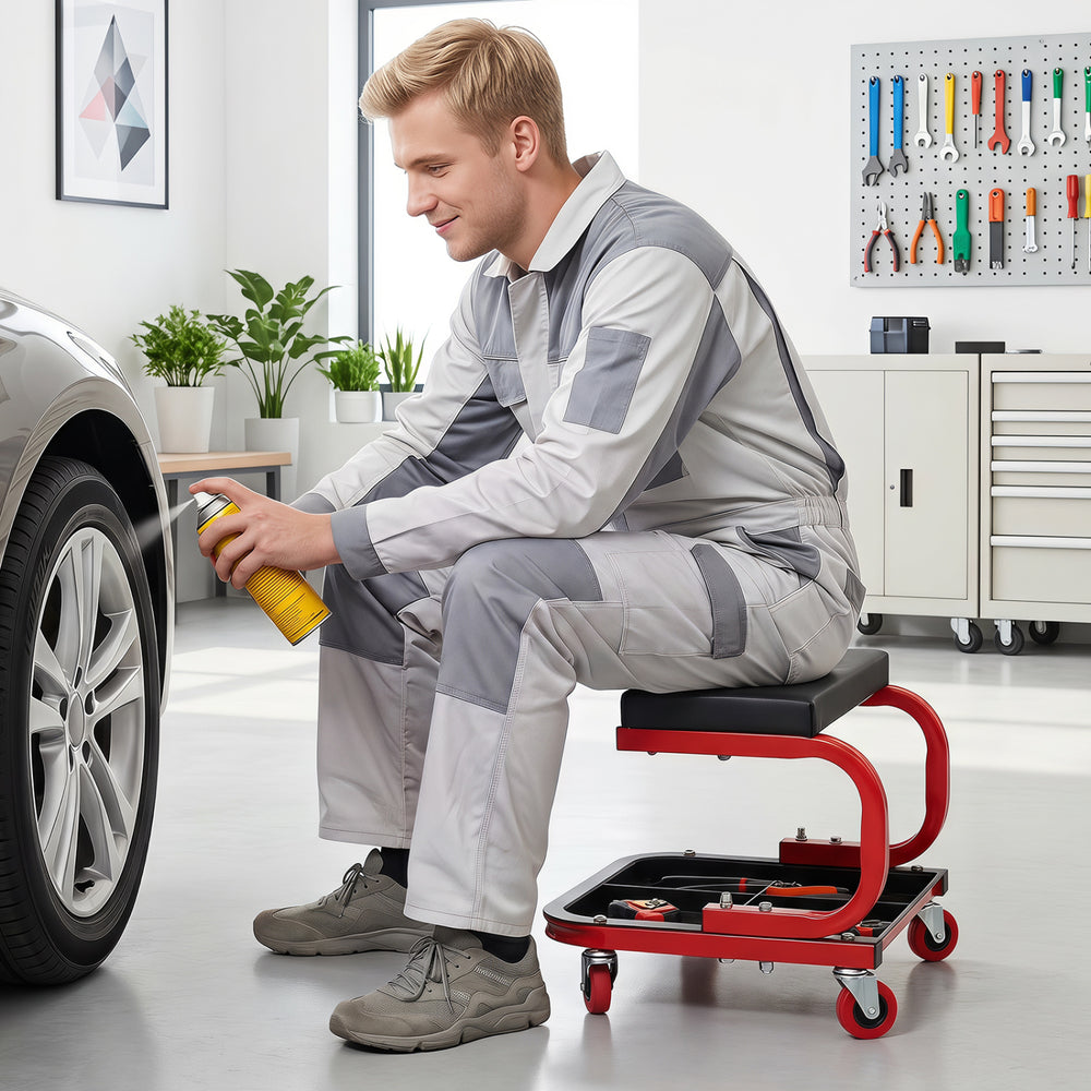 Mechanic rolling stool in red with tool trays and magnetic drawer, designed for comfort and mobility in garages.