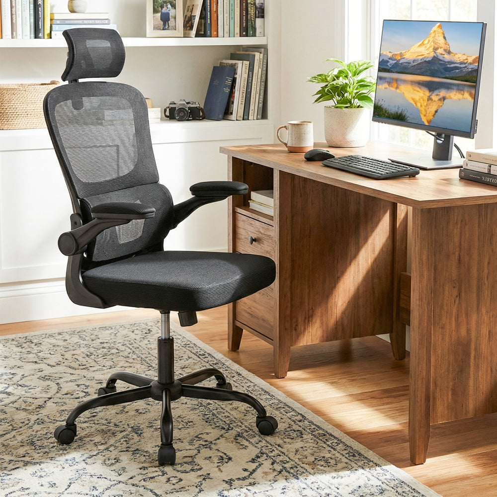 Ergonomic black mesh office chair with adaptive lumbar support and flip-up armrests, ideal for long hours of work.