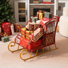 Red metal Christmas Santa sleigh basket with gold base, filled with wrapped gifts, perfect for festive storage and.