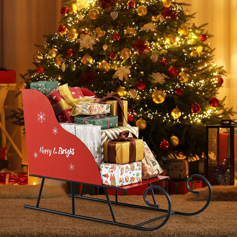 Red metal Christmas Santa sleigh basket adorned with festive motifs, ideal for showcasing gifts in holiday celebrations.