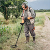 Metal detector with adjustable length and backlit LCD display, ideal for treasure hunting in various terrains.