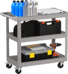 3-tier gray metal utility cart with flat handle, lockable wheels, and ample storage for tools in a garage setting.
