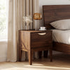 Mid Century Modern bedside table in walnut with a drawer, tapered legs, and a smooth wood grain finish for bedroom use.