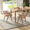 Mid-century wooden accent chairs with beige leathaire cushions, featuring ergonomic design, in a bright dining area.
