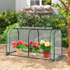 Mini tunnel greenhouse showcasing a roll-up zipper door, secured with U-shaped stakes, ideal for cultivating seedlings.