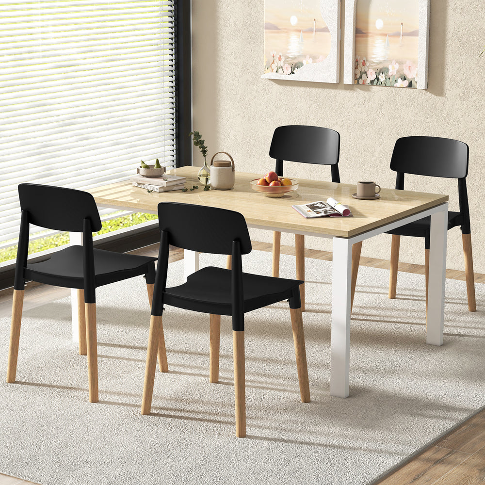 Set of four black ergonomic dining chairs with beech legs, stylishly arranged around a modern dining table.