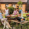 Outdoor pizza oven with foldable legs, cooking a pizza outdoors, ideal for camping and quick meals.