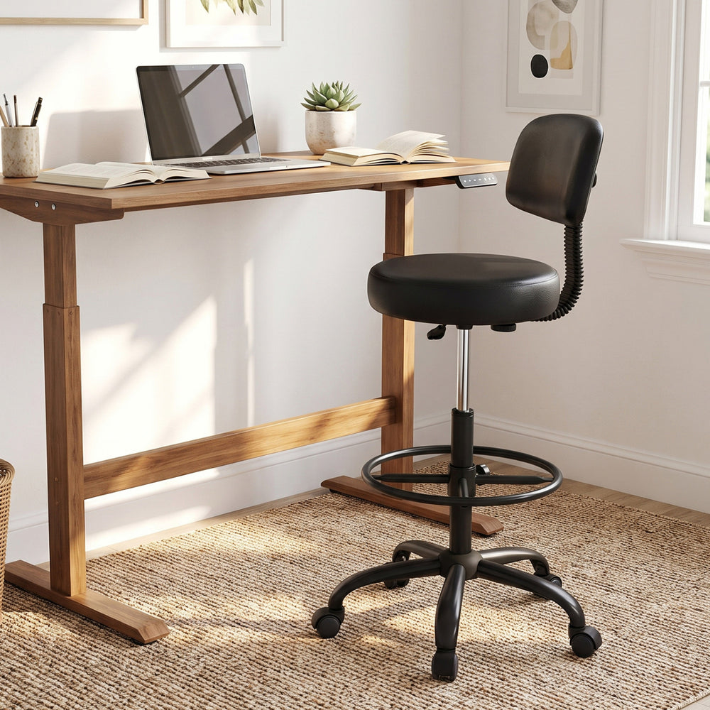 Black office drafting chair with adjustable footring and wheels, featuring a contoured backrest for ergonomic comfort.