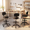 Black office drafting chair with adjustable footring and wheels, designed for ergonomic sitting at craft tables.