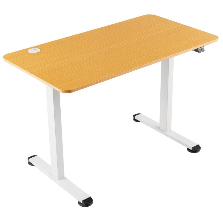 Electric standing computer desk with bamboo finish, adjustable height, and built-in cable grommet for a tidy workspace.
