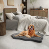 Orthopedic dog bed in gray with memory foam support, perfect for large dogs, placed beside a bed in a cozy bedroom.