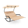 Beige outdoor rocking chaise lounge for 2 with adjustable canopy and wheels, perfect for poolside relaxation.