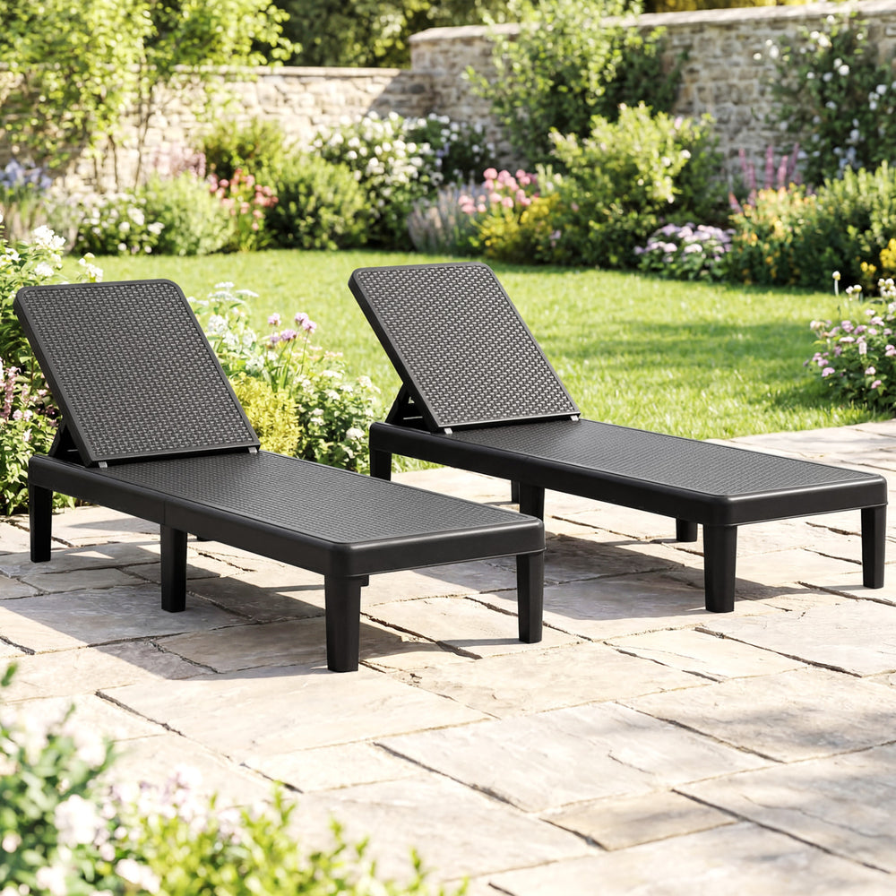 Set of 2 black outdoor chaise loungers with waterproof rattan textured surface, perfect for sunbathing and relaxation.