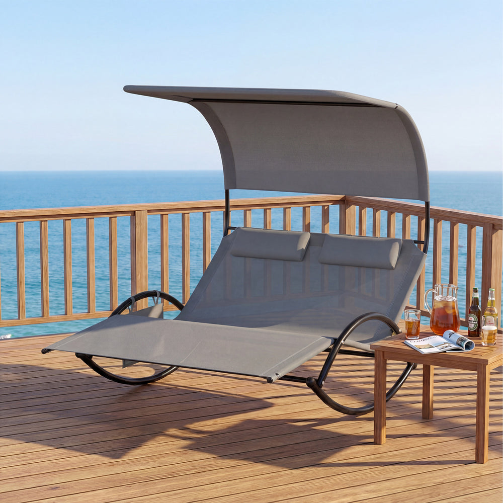 Gray outdoor dual rocker sunbed with canopy and detachable headrests, perfect for poolside relaxation.