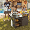 Outdoor grill cart with stainless steel top, storage shelves, and cabinet, perfect for outdoor cooking and gatherings.