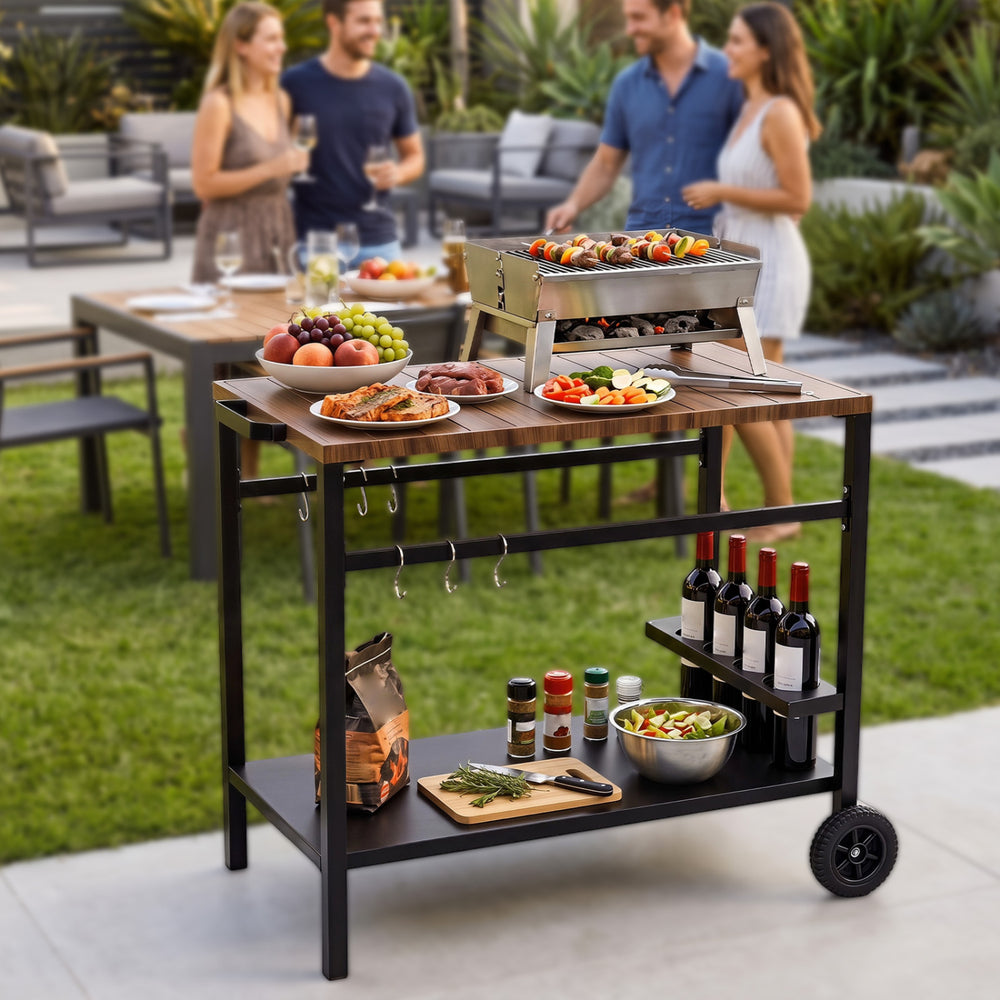 Outdoor grill cart with stainless top, spice rack, and hooks, ideal for efficient outdoor cooking and gatherings.