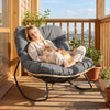 Outdoor Papasan rocking chair with thick gray cushion, providing ergonomic support for relaxing patio moments.