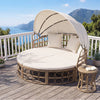 Round outdoor patio daybed with a retractable canopy, yellow wicker rattan, and plush cushions, perfect for balcony lounging.