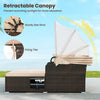 Outdoor patio rattan daybed with retractable canopy, beige cushions, and side tables for comfortable relaxation.