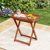Foldable outdoor patio tray table made of solid wood with removable top, perfect for serving snacks in the garden.