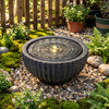 Outdoor round sphere water fountain with LED lights, featuring a realistic stone-like design for tranquil garden.
