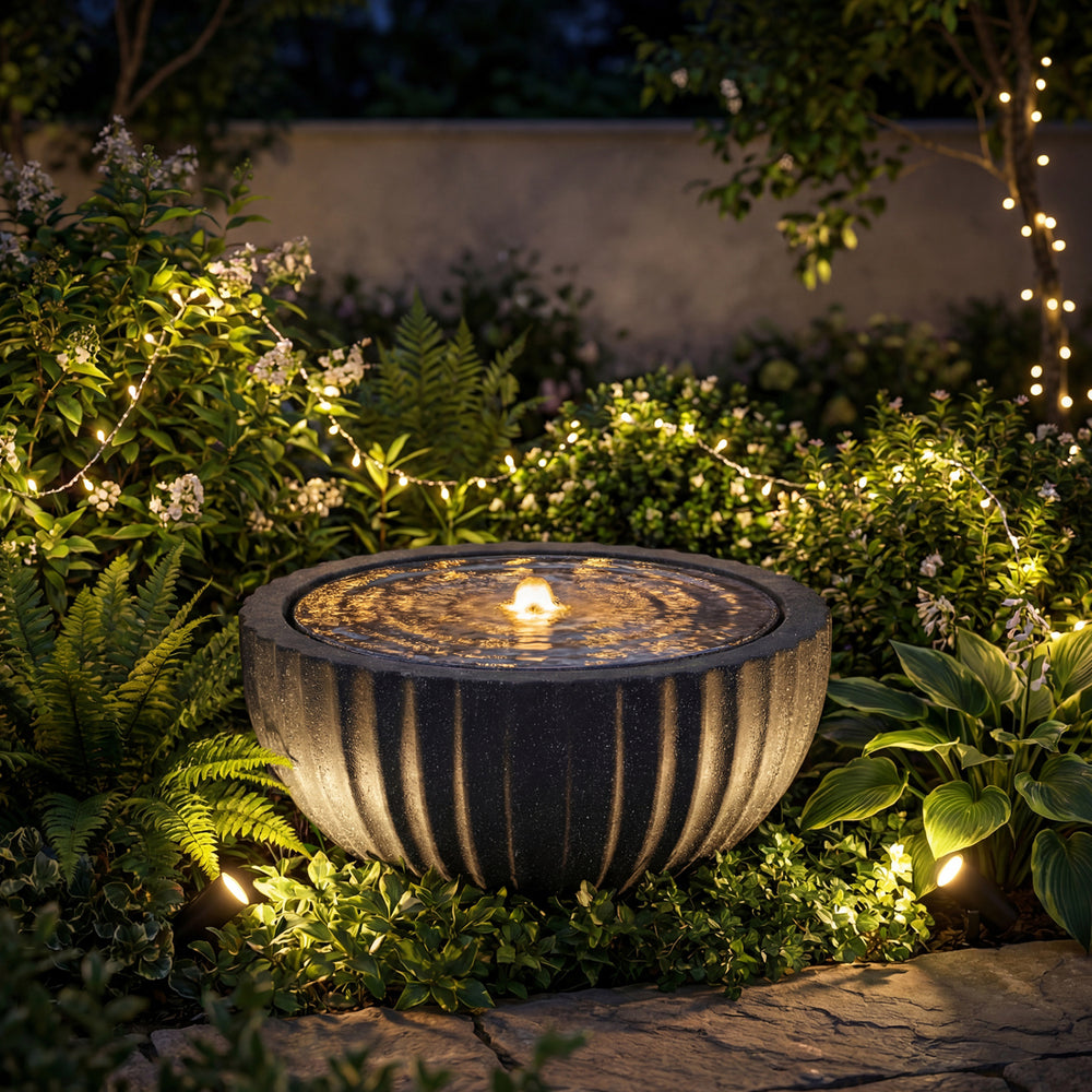 Outdoor round sphere water fountain with LED lights, featuring a realistic stone look, ideal for tranquil garden.