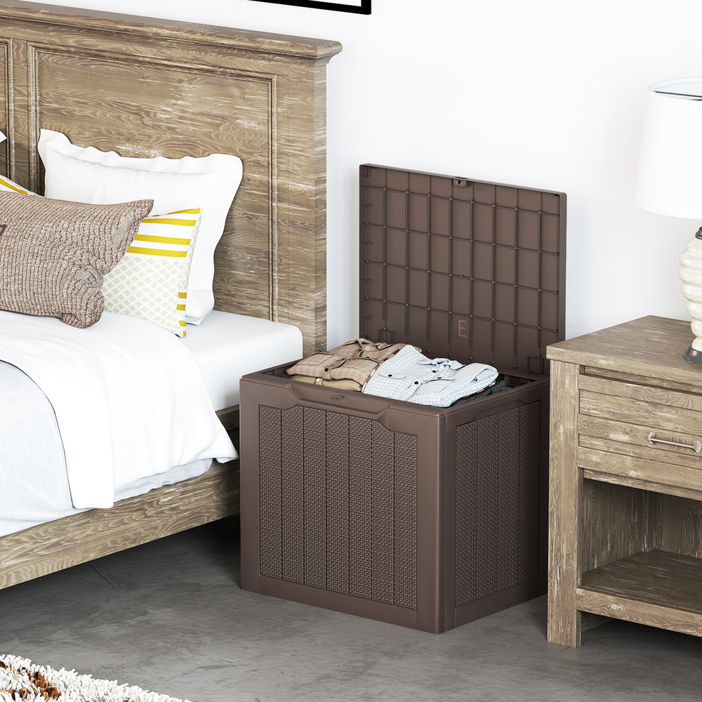 Brown outdoor storage box with wicker-woven texture, 25-gallon capacity, ideal for cushions and blankets beside a bed.
