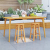 Set of two 24-inch outdoor wood bar stools with round seats and footrests, perfect for patio or garden use.