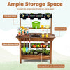 Outdoor wood mud kitchen for kids features a water faucet, planter, and ample storage for gardening tools and toys.