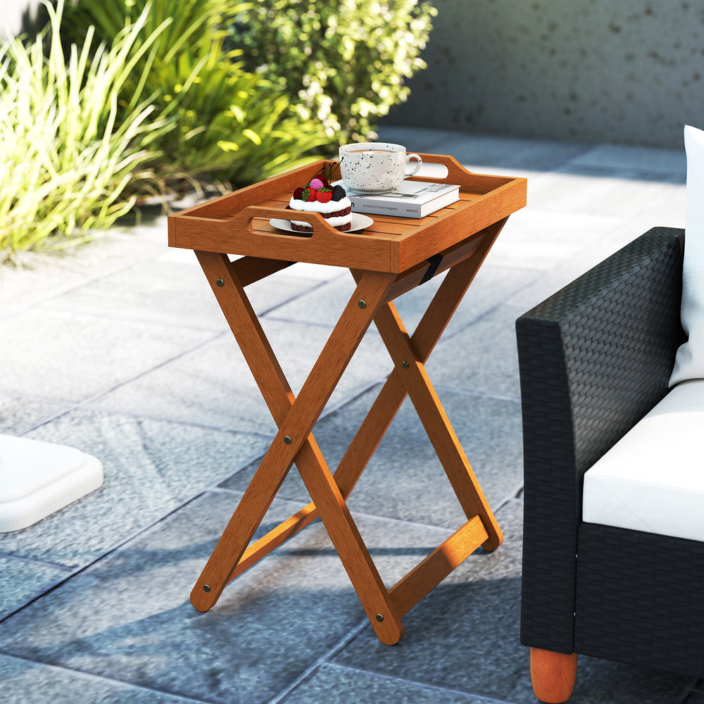 Portable outdoor wood tray table with folding frame, featuring a natural finish and side cut-out handles for easy.