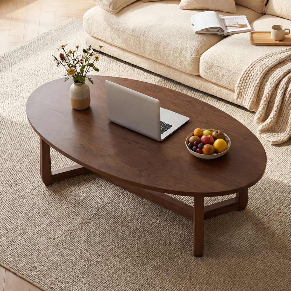 Oval coffee table with a thickened walnut top, featuring a stable V-shaped base, ideal for snacks and laptops.