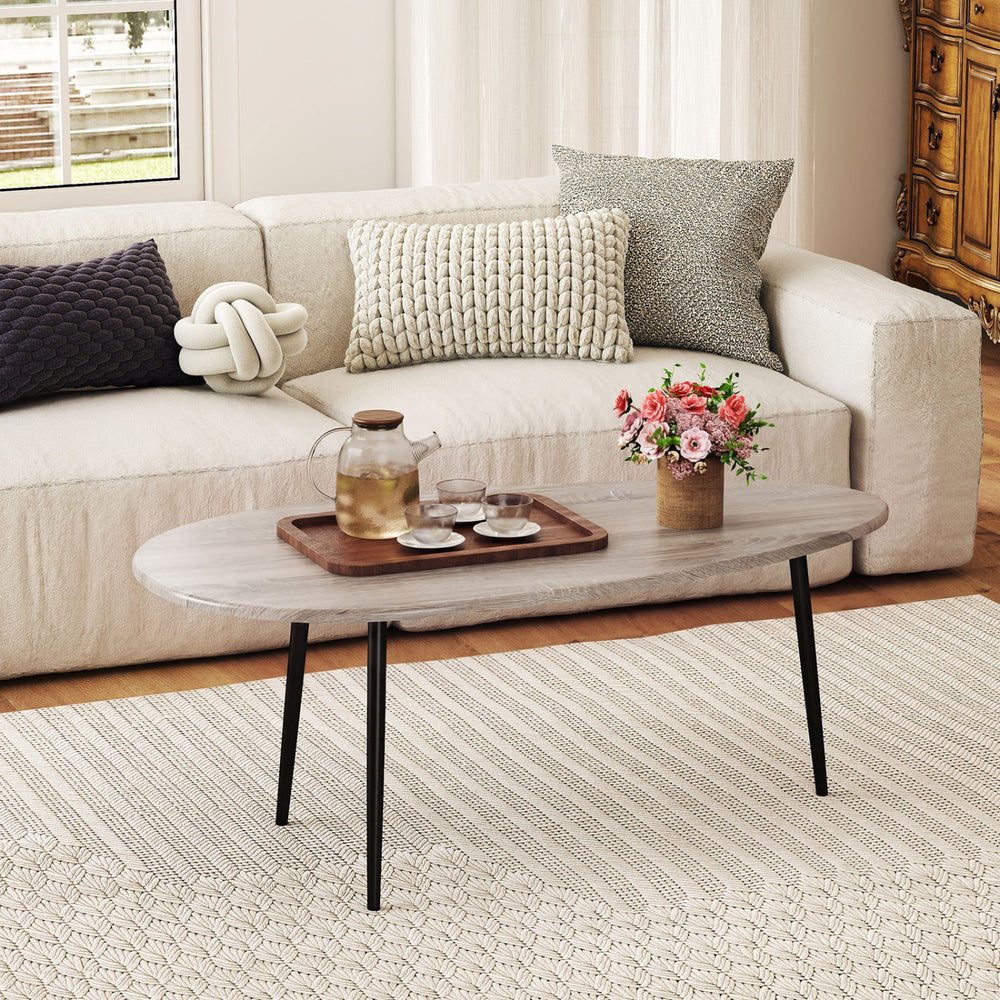 Mid-century oval coffee table in gray with sturdy metal legs, perfect for living room organization and style.