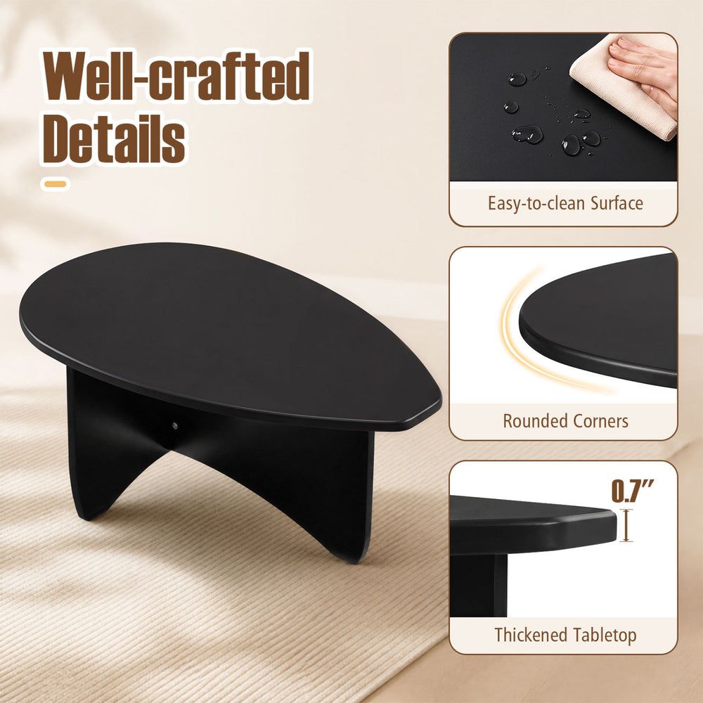 Oval black coffee table with a thickened 0.7" tabletop and rounded corners, perfect for low-profile lounging.