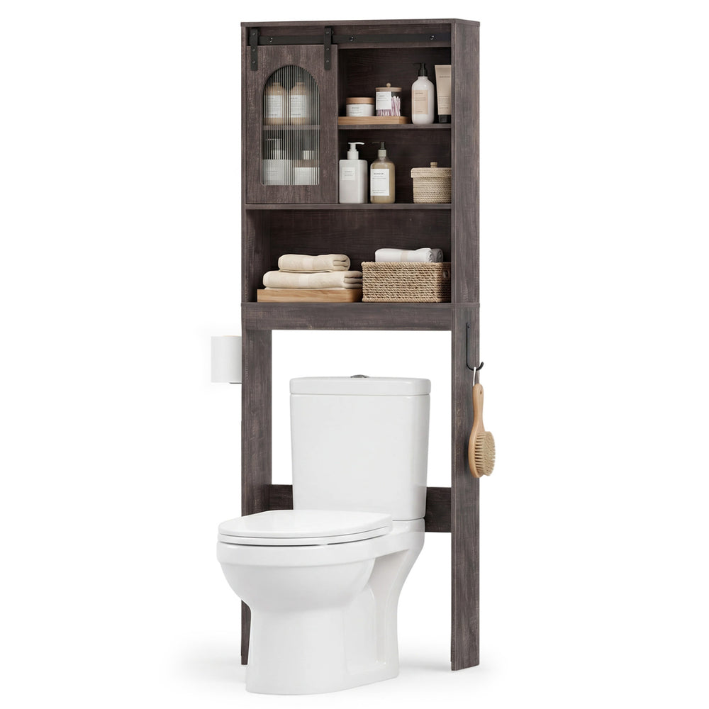 Over toilet storage cabinet in oak with sliding barn door, open shelves, and hooks for towels and toilet paper.