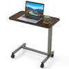 Overbed table with walnut finish, adjustable height, and lockable rolling wheels for versatile home or hospital use.