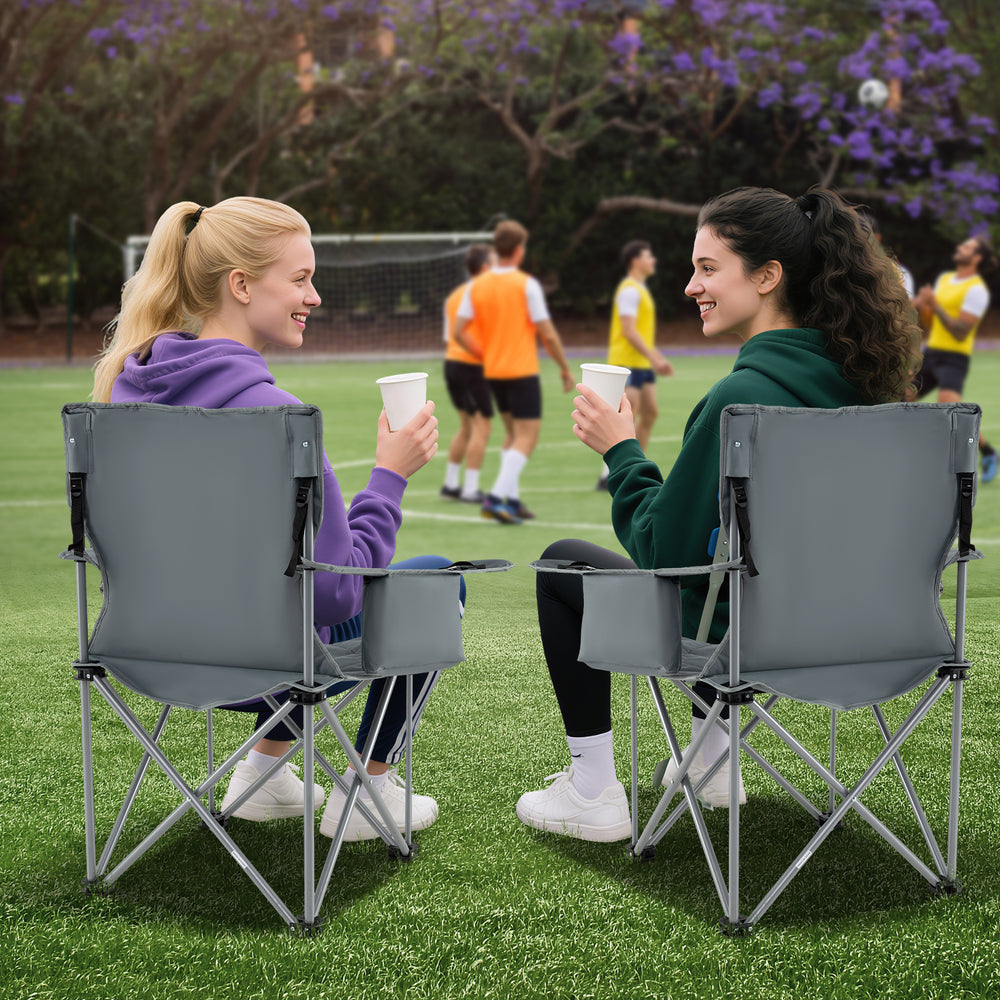 Two friends enjoying drinks in gray oversized camping chairs with cup holders, perfect for outdoor events and.