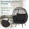 Oversized indoor wicker egg chair in light brown PE rattan with black cushions, perfect for cozy relaxation.