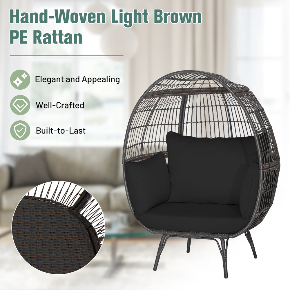 Oversized indoor wicker egg chair in light brown PE rattan with black cushions, perfect for cozy relaxation.