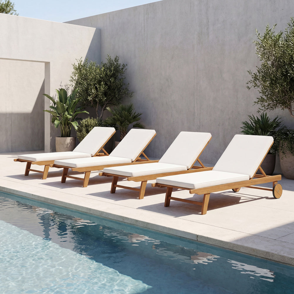 Set of four acacia wood lounge chairs with white cushions, perfect for poolside relaxation and outdoor comfort.