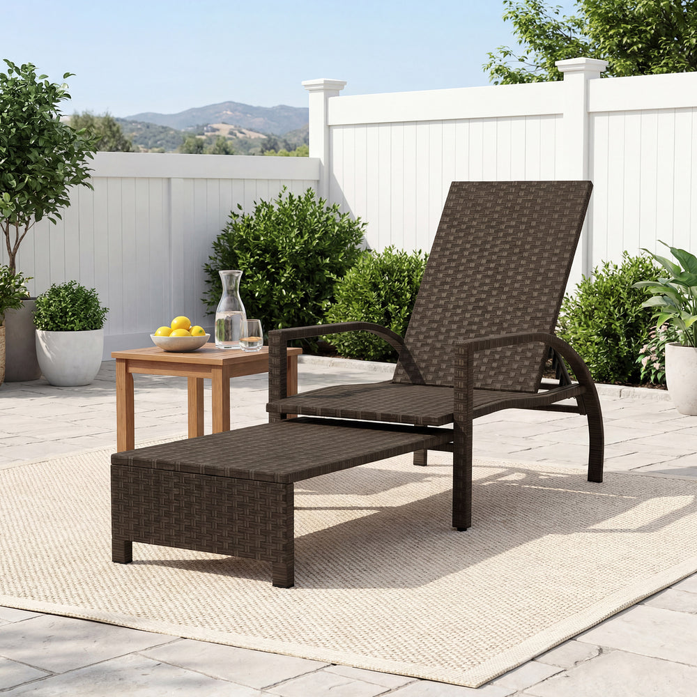 Patio chaise lounge with retractable ottoman, durable rattan, adjustable backrest, perfect for backyard relaxation.