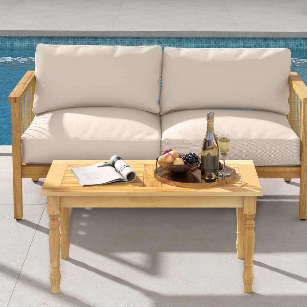Stylish patio coffee table showcasing a slatted design and solid teak wood structure, perfect for relaxation by the.